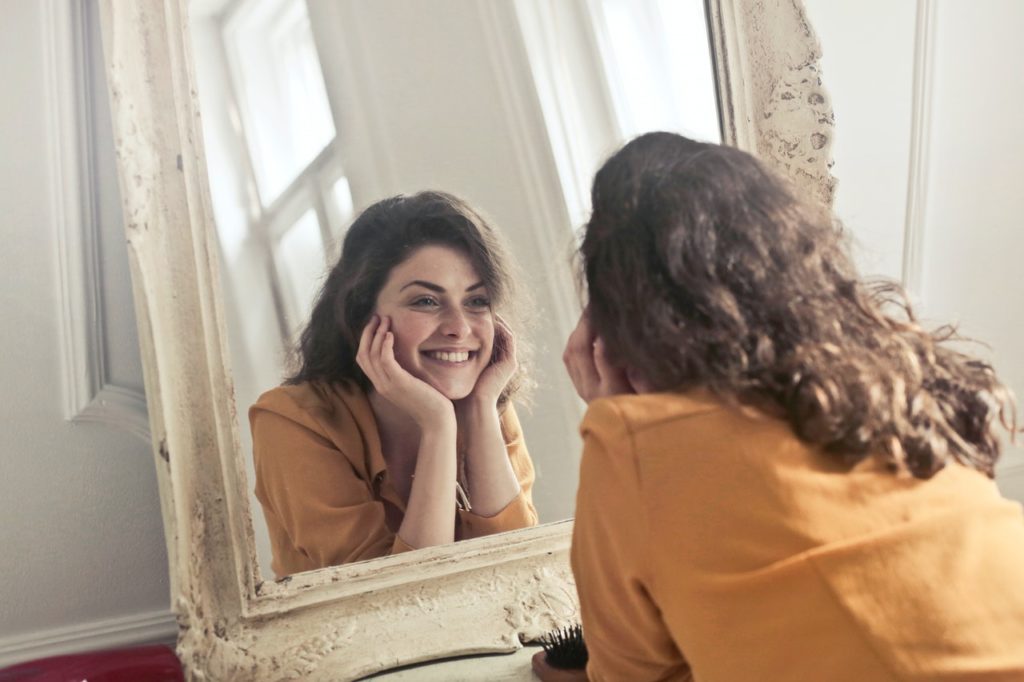 happy woman looking at mirror